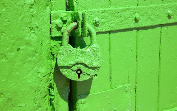 Cerradura de metal verde está colgando para proteger la entrada a través de puertas —  Fotos de Stock