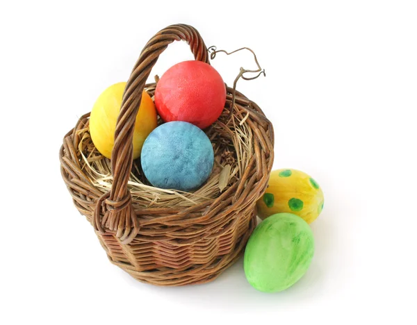 Huevos de Pascua en una canasta sobre un fondo blanco Imagen De Stock