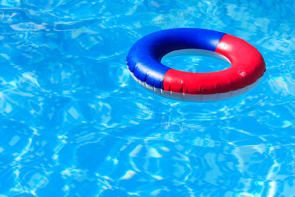 Un anillo inflable colorido flotando en una piscina — Foto de Stock
