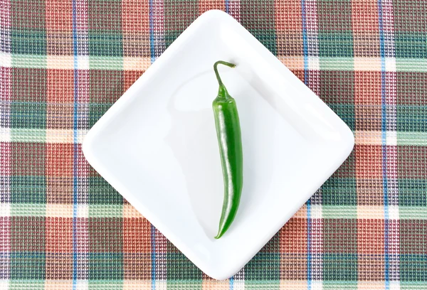 Un chile verde en un plato blanco — Foto de Stock