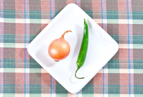 stock image Green chili pepper and onion on a white plate