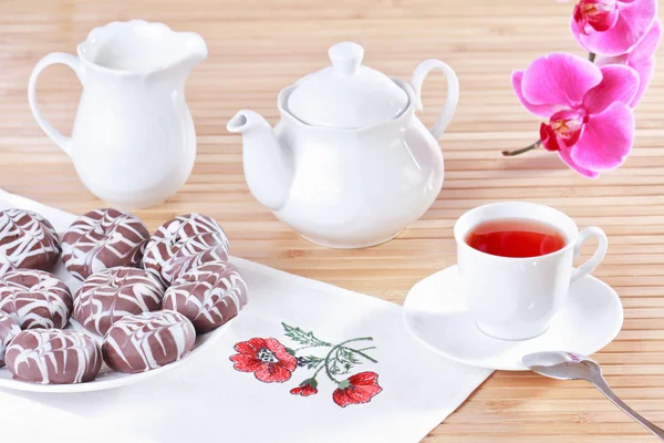 Cup of tea, teapot and chocolate iced spice cakes — Stock Photo, Image