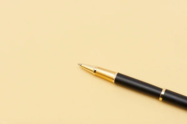 Złoty długopis na żółtej kartce papieru — Zdjęcie stockowe
