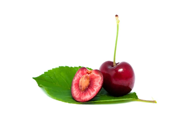 Одна красная вишня с половиной на листе — стоковое фото