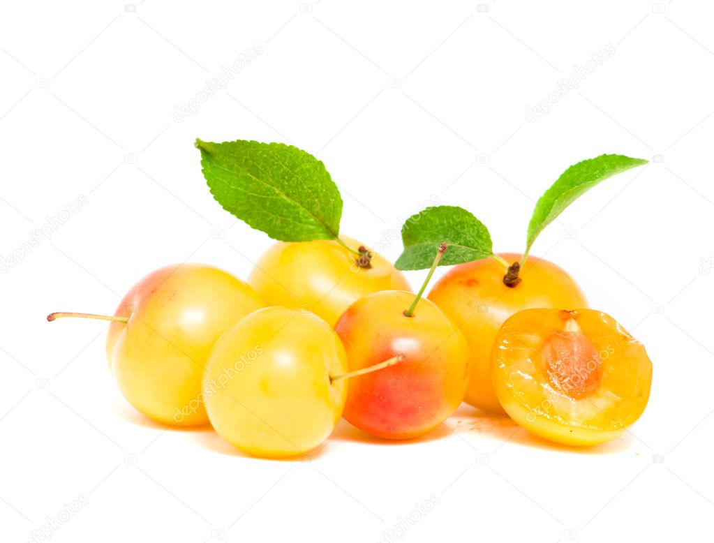 Pile of fresh yellow plums with leafs