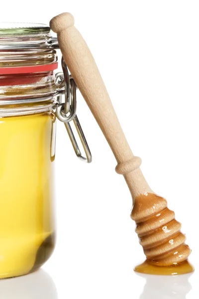 Honig bedeckte Honiglöffel lehnt an einem Honigglas — Stockfoto