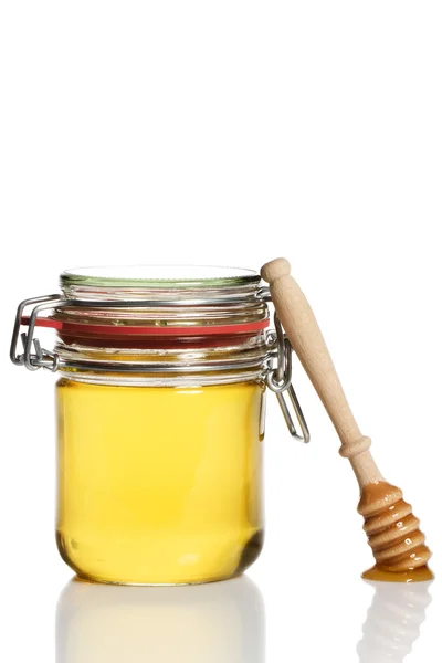 蜂蜜、蜂蜜の瓶で傾いている蜂蜜ディッパー覆われています。 — ストック写真