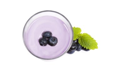 Blueberries on top of a blueberry milkshake with blueberries aside clipart