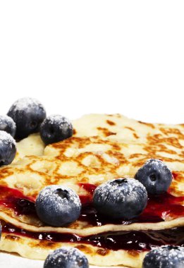 Sugar covered blueberries on pancakes with jam clipart