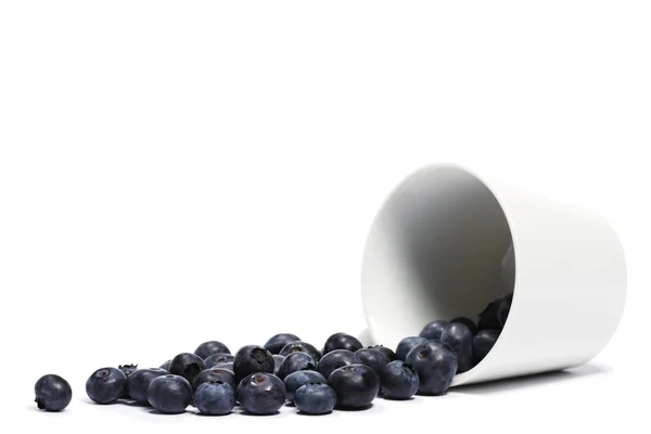 Blueberries rolando de um caiu sobre o copo — Fotografia de Stock
