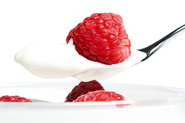 Крупный план малины на ложке с йогуртом — стоковое фото