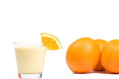 Piece of a orange on a milkshake in front of oranges clipart