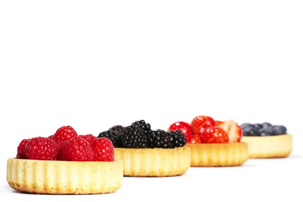 Raspberries in tartlet cake in front of others — Stock Photo, Image