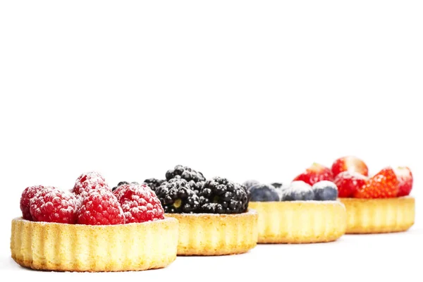 Sugar covered raspberries in tartlet in front of wild berries — Stock Photo, Image