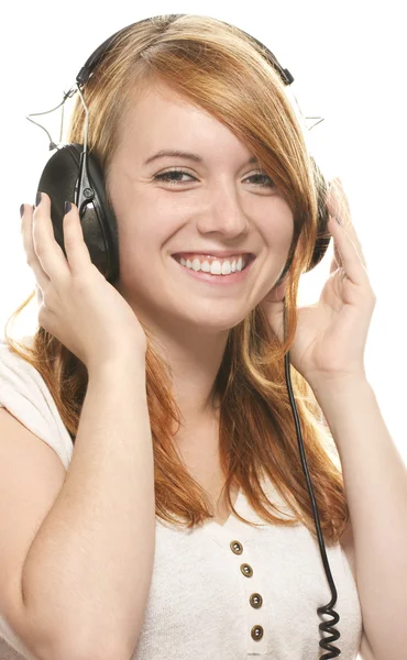 Skrattar rödhårig tjej med hörlurar lyssna på musik — Stockfoto