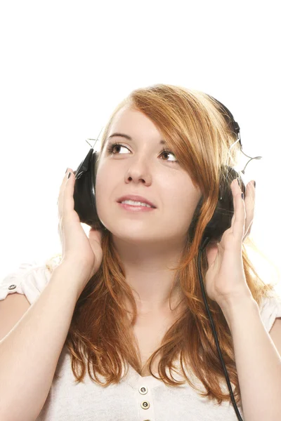 Jeune rousse femme est rêveuse tout en écoutant de la musique avec casque — Photo