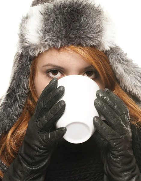 Νεαρή γυναίκα το χειμώνα φόρεμα πίνοντας καφέ ή τσάι από ένα φλιτζάνι — Φωτογραφία Αρχείου