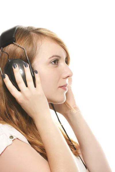 Joven pelirroja soñadora escuchando música con sus auriculares — Foto de Stock
