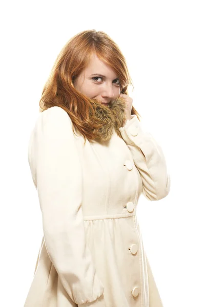Jonge redhead vrouw die betrekking hebben op haar gezicht in Fauve winterjas — Stockfoto