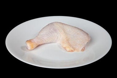 Chicken leg on a white plate is isolated on a black background