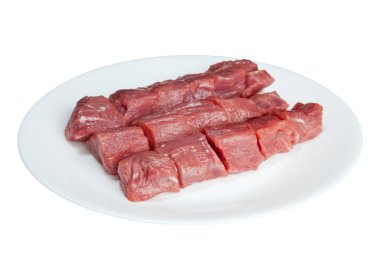 Pieces of raw meat on a white plate