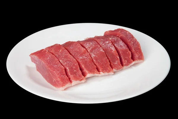 Κομμάτια από το ωμό κρέας σε ένα άσπρο πιάτο — Φωτογραφία Αρχείου