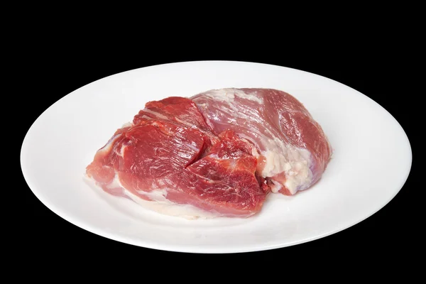 Stücke rohen Fleisches auf einem weißen Teller — Stockfoto