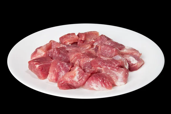 Pieces of raw meat on a white plate — Stok fotoğraf