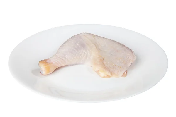 Chicken leg on a white plate is isolated on a black background — Stock Photo, Image