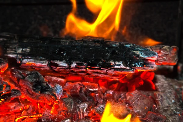 Arrière-plan d'un feu, des bois de chauffage et des charbons embrasés — Photo