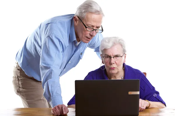 Ancianos hombre y mujer detrás de la computadora portátil — Foto de Stock