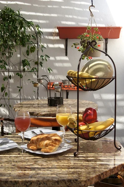 Leerer tropischer Cafétisch mit Fruchtsaft und Croissants — Stockfoto