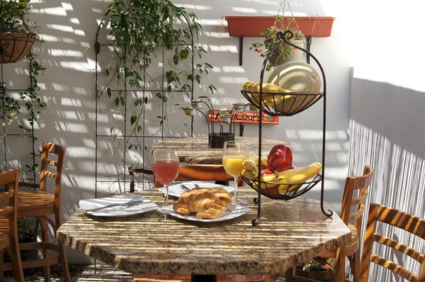 Semi venkovní tropické café tabulka s ovocné šťávy a croissanty — Stock fotografie
