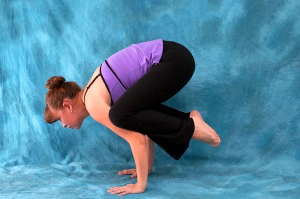 Vista lateral izquierda de la mujer en postura de cuervo de yoga —  Fotos de Stock