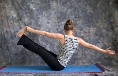 Yoga duruş navasana varyasyon veya tekne poz yapıyor kadın