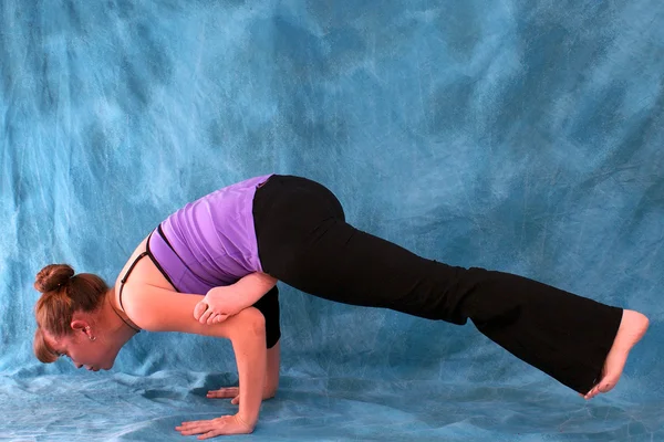 Женщина в позе йоги летающей вороны — стоковое фото