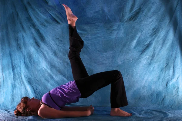 Kvinna i en fyrbent bro yoga utgör — Stockfoto