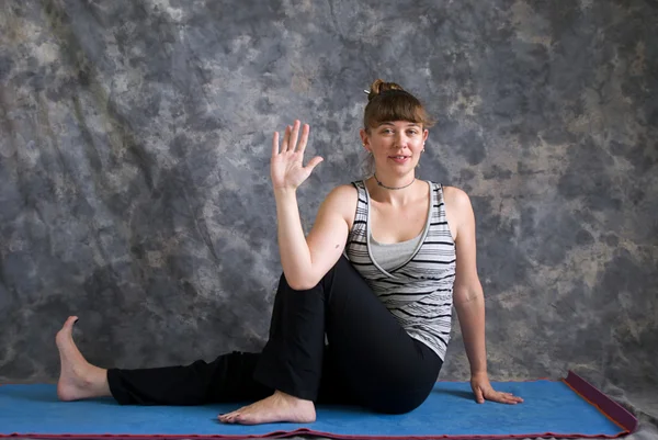 Mulher fazendo postura de Yoga Eka Pada Parivrtta Upavisthasana ou Um — Fotografia de Stock