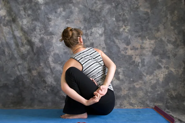 Mulher fazendo postura de Yoga Baddha Ardha Matsyendrasana ou ligado lo — Fotografia de Stock
