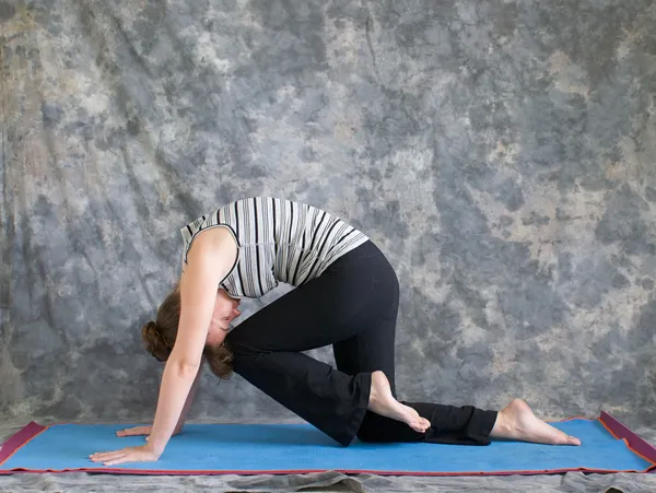 Vrouw doen yoga houding marjaryasana variatie of sterke kat po — Stockfoto