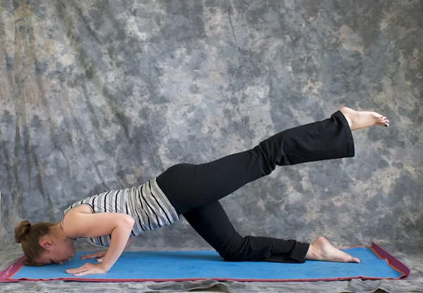 Woman doing Yoga posture sunbird pose left — Stock Photo, Image