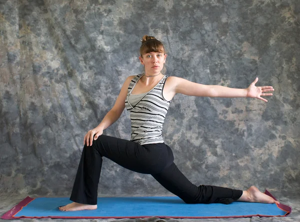 Frau, die Yogaposition macht, dreht niedrigen Ausfallschritt oder Ashwa Sanchalanasa — Stockfoto