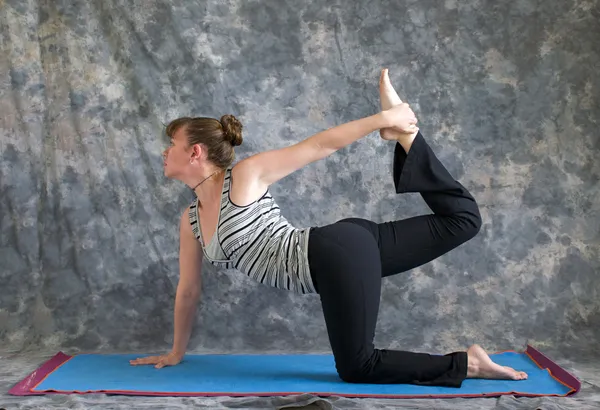 Donna che fa Yoga postura Vyaghrasana La Tigre Posa variazione — Foto Stock