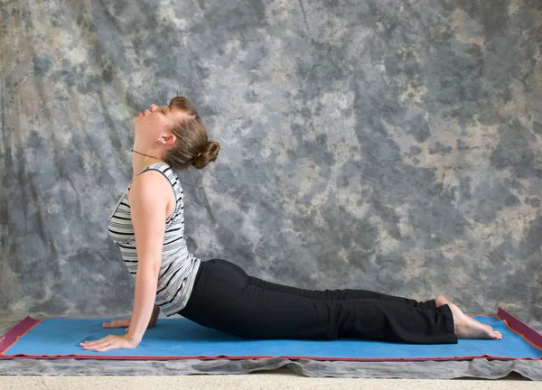 Mulher fazendo postura de Yoga Bhujangasana ou pose de cobra — Fotografia de Stock