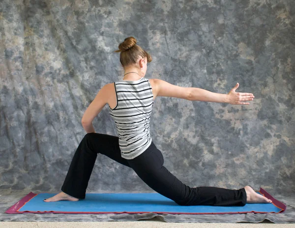 Frau, die Yogaposition macht, dreht niedrigen Ausfallschritt oder Ashwa Sanchalanasa — Stockfoto