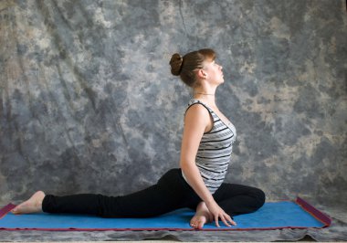 Yoga duruş Sirasana kapotasana yapıyor veya p desteklenen genç kadın