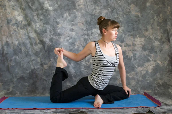 Kvinnan gör yoga posture kapotasana eller duva pose variant 2 — Stockfoto