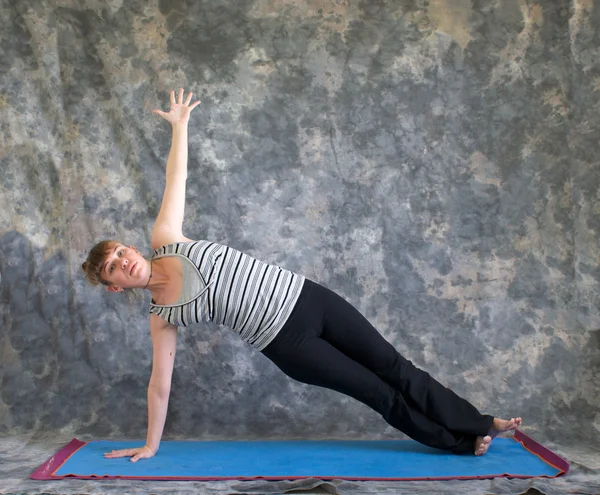 Vrouw doen yoga houding vasisthasana of zijkant plank pose — Stockfoto