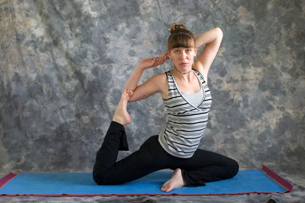 Genç kadın Yoga duruş kapotasana veya güvercin poz variati yapıyor — Stok fotoğraf