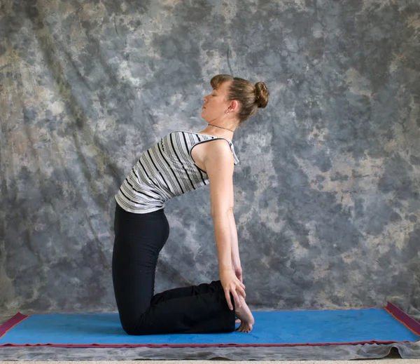 Giovane donna che fa Yoga postura Ustrasana o cammello posa — Foto Stock
